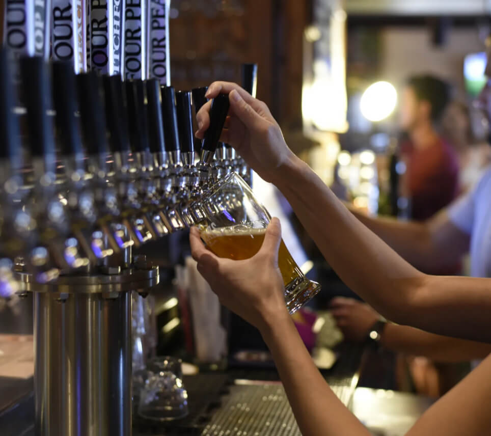 A beverage being poured from a tap at a brewery